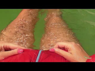 In roter Daunenjacke im Pool schwimmen