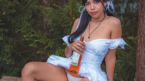 Latina Frau trinkt eine Flasche Alkohol und geht mit Vergnügen