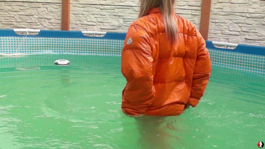 Christina in orange down jacket swimming in the pool